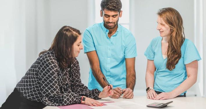 three people signing a housing agreement